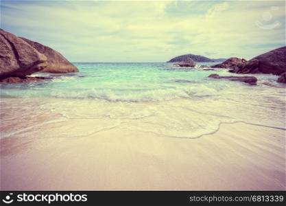 Vintage style beautiful nature of blue sea sand and white waves on small beach near the rocks during summer at Koh Miang island in Mu Ko Similan National Park, Phang Nga province, Thailand