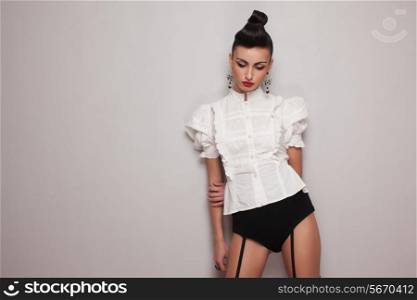 Vintage style leggy model posing in white shirt and black high shorts
