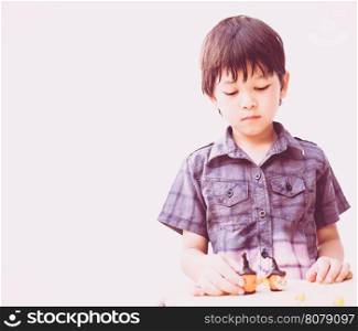 Vintage style of Asian lovely boy is playing Halloween clay happily