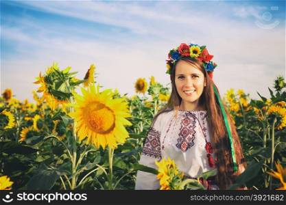 Vintage style photo of beautiful young woman at sunflower field