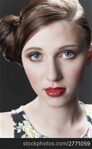 Vintage style portrait of model with red hair tied in a bun