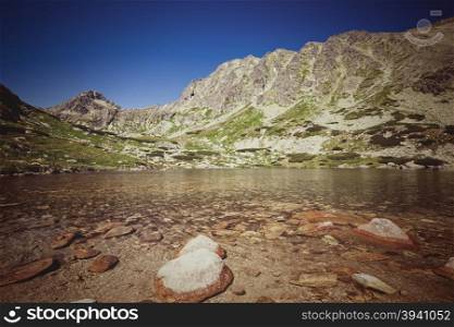 Vintage style summer alpine mountain lake