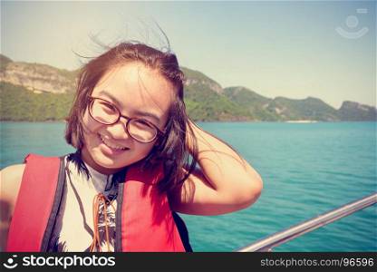 Vintage style woman on the boat. Vintage style young woman with eyeglasses smiling happily on the boat while cruising the natural of the sea and island in summer at Mu Ko Ang Thong National Park, Surat Thani, Thailand
