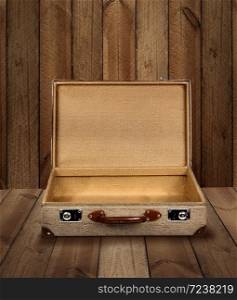 Vintage suitcase opened on rough wooden plank background