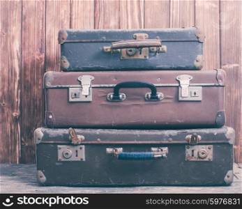 Vintage suitcases over wooden wall, retro style
