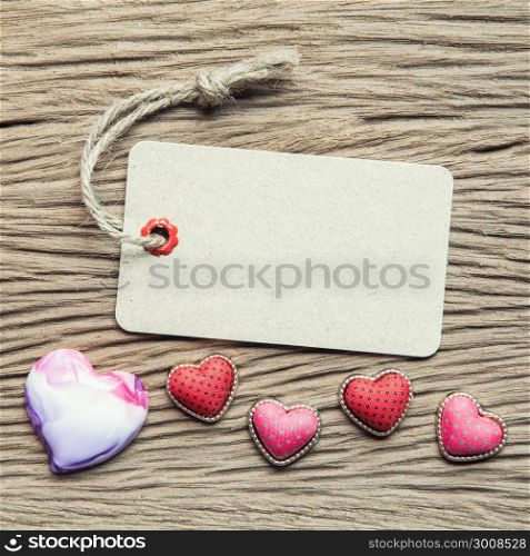 Vintage tag with hearts on wood texture for valentine and wedding background.