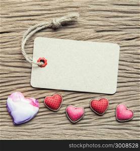 Vintage tag with hearts on wood texture for valentine and wedding background.