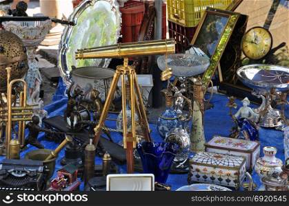 Vintage telescope and antiques for sale at street market.