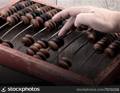 Vintage tone of Man&rsquo;s hands accounting with old abacus .financial concept design.