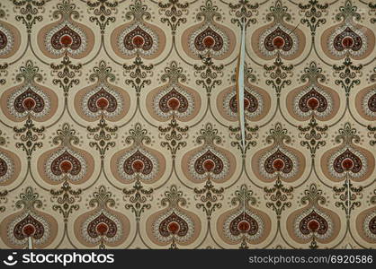 Vintage torn and dirty wallpaper with old fashioned pattern. Abstract retro background.