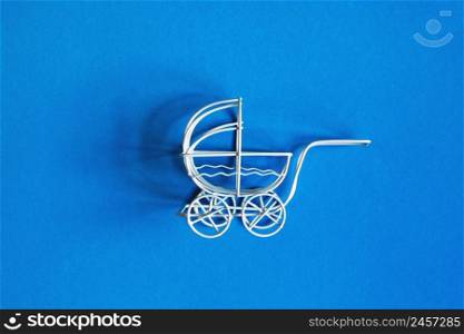 vintage toy baby stroller on a blue background. toy carriage. vintage toy baby stroller on blue background. toy carriage