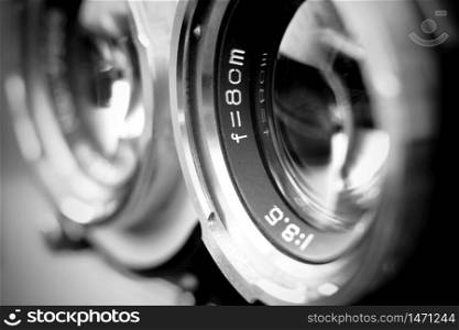 Vintage twin reflex camera lens with shallow depth of field in black and white. Retro style medium format camera lens in blur. Vintage film camera lens.