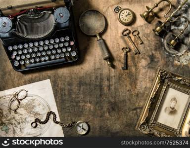 Vintage typewriter, golden frame, old office accessories on wooden background