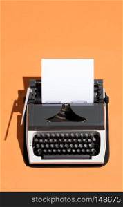 Vintage typewriter with a white blank sheet of paper in it. Journalism. Top view.. Vintage typewriter with a white blank page