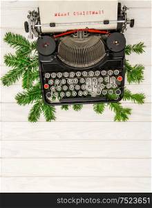Vintage typewriter with christmas decoration evergreen tree brunches. Merry Chrismas!