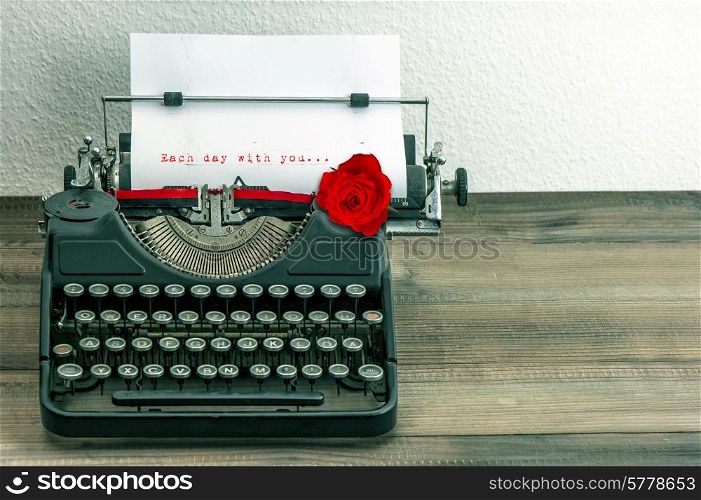 vintage typewriter with love letter and red rose flower. sample text Each day with you...