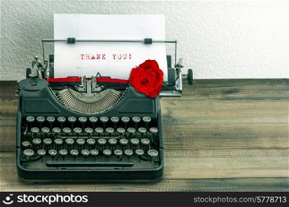 vintage typewriter with white paper page and red rose flower. sample text Thank You!