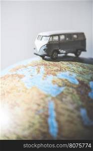 Vintage VW bus on globe. Miniature concept
