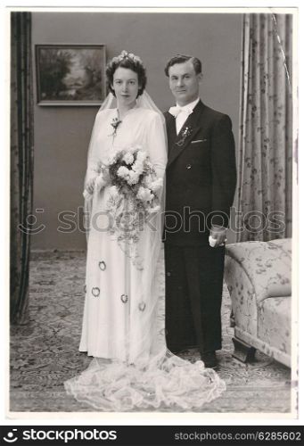 vintage wedding photo. portrait of just married couple. bride and groom wearing vintage clothing. Illustrative Image, subject of human interest. nostalgic picture with original film grain