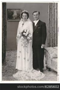 vintage wedding photo. portrait of just married couple. bride and groom wearing vintage clothing. Illustrative Image, subject of human interest. nostalgic picture with original film grain