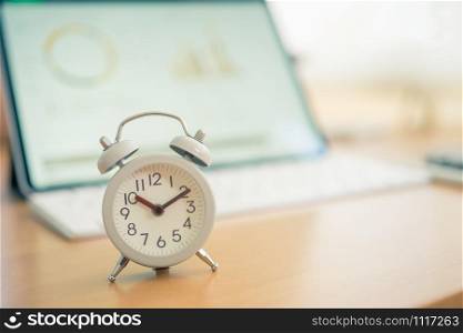 Vintage White Alarm Clock on on a NoteBook. It&rsquo;s time to rest. using as background Relaxing time concept with copy spaces for your