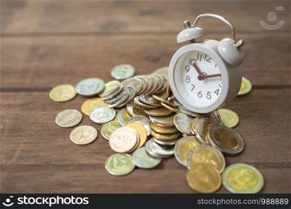 Vintage White Alarm Clock on the pile of money. as background business concept and Saving concept with copy space for your text or design.