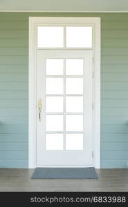 vintage white door on the green wall with a grey carpet