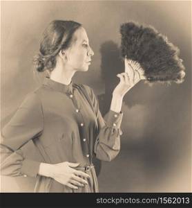 Vintage woman retro style with black feather fan sepia tone
