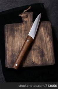 Vintage wooden cutting board with towel and knife. Kitchen cooking concept. Space for text