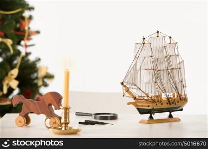 Vintage Wooden Horse and Ship on Santa's work table, Christmas Tree on background