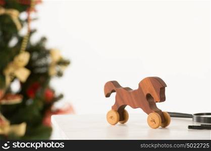 Vintage Wooden Horse on Santa's work table, Christmas Tree on background