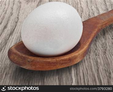 vintage wooden spoon with egg on the table