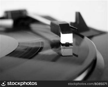 Vinyl record spinning. Vinyl record spinning on a turntable, focus on needle - in black and white