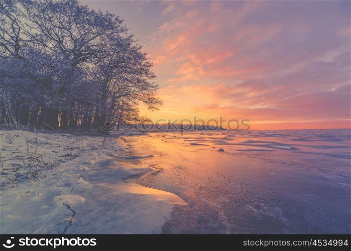 Violet sunrise over a frozen lake in the winter