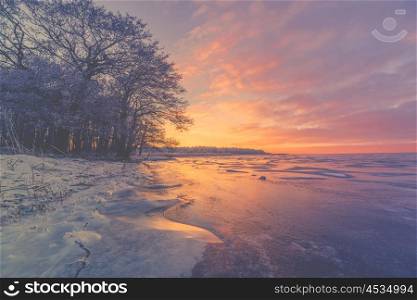 Violet sunrise over a frozen lake in the winter
