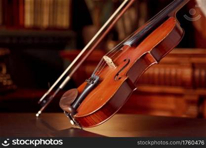Violin in retro style and bow, closeup view, nobody. Classical string musical instrument, old viola, dark background. Violin in retro style and bow, closeup view
