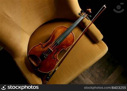 Violin musical instrument on the chair. Violinist equipment for music performance. Violin musical instrument on the chair