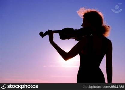 violin player performing solo at sunset