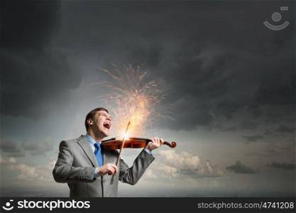 Violin player. Young emotional businessman playing with passion violin instrument
