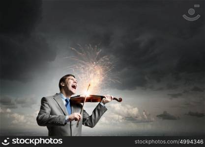 Violin player. Young emotional businessman playing with passion violin instrument