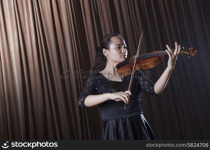 Violinist standing and playing the violin at a performance