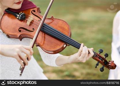 Violinist woman. Young woman playing a violin outside.