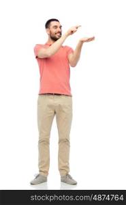 virtual, augmented reality and people concept - happy man in polo t-shirt touching and holding something imaginary on hand over white background