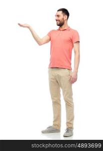 virtual, augmented reality and people concept - happy man in polo t-shirt holding something imaginary on hand over white background