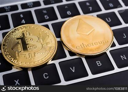 Virtual Bitcoin and Ethereum coins currency finance money on computer laptop keyboard
