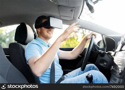 virtual reality, technology and driving concept - smiling man or driver wearing vr glasses in car. man or driver wearing vr glasses and driving car