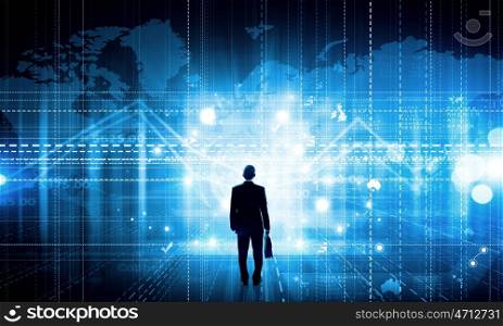 Virtual technologies. Back view of businessman with suitcase in hands looking at virtual panel