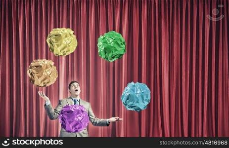 Virtuoso of creative ideas. Businessman juggling with crumpled balls of colorful paper as creativity sign