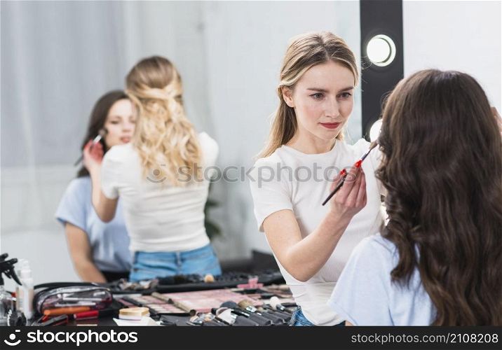 visagiste creating professional makeup woman studio