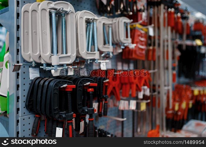 Vise and clamps on racks in tool store closeup, nobody. Choice of equipment in hardware shop, professional instrument in supermarket. Vise and clamps on racks in tool store closeup
